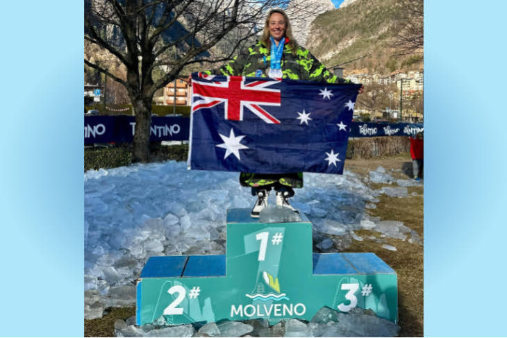 Peta Bradley standing on the Molveno podium proudly brandishing the Australian flag. Photo supplied.