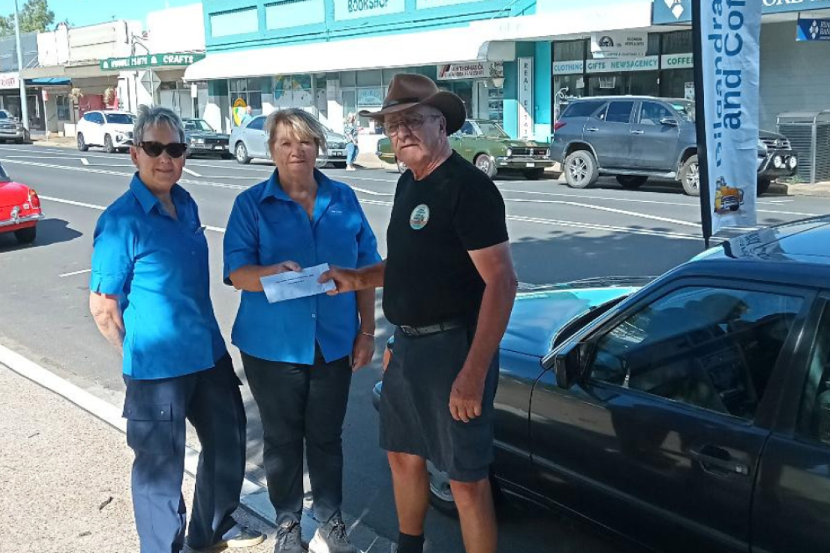 Annette Long and Barb Whale accepting a donation from Gilgandra Tractor and Machinery Club president Barry Robinson. Photo supplied.