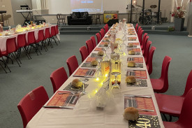 Tables set for the Saturday evening meal in the church auditorium.
